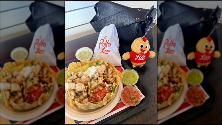 An El Pollo Loco Double Chicken Tostada sits on a restaurant tray next to a woman's purse with an El Pollo Loco keychain attached to it