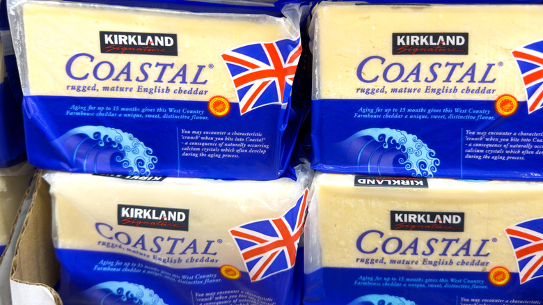 Kirkland Signature Coastal Rugged Mature English Cheddar blocks are stacked in a display.