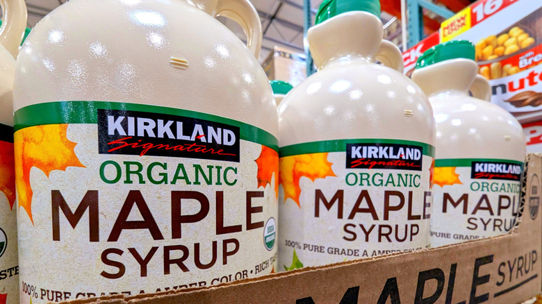 Jugs of Kirkland Signature Organic Pure Maple Syrup are on display in a store.