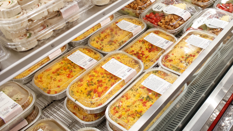 Ready-made Rotisserie Chicken Enchilada Bake meals are on display in Costco cooler.