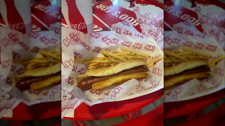 A hot dog sits in a paper boat with fries at Busch Stadium.