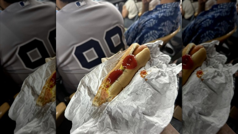 A hand holds a hot dog in Dodger Stadium.