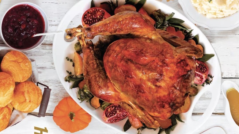 Roasted turkey with sectioned pomegranate surrounded by sides