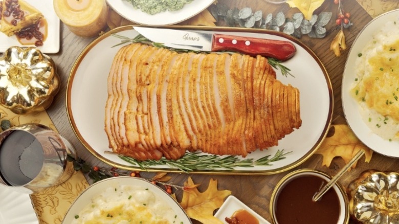 Sliced turkey centered on a table set for Thanksgiving