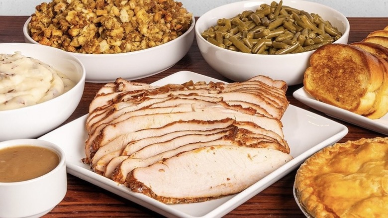 Thanksgiving turkey cut up with sides of green beans and bread