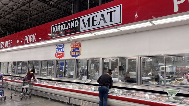 landscape image of Costco meat department with two shoppers