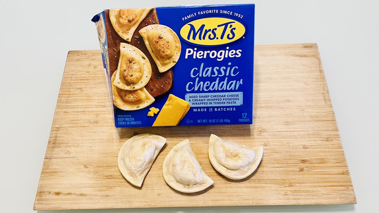 Box of Mrs. T's Classic Cheddar Pierogies with cooked ones alongside