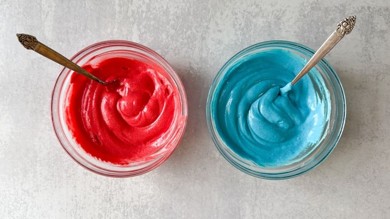 Red and blue cake batter in glass bowls
