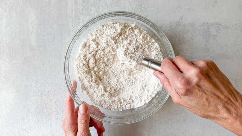 Whisking together dry vanilla cake ingredients in glass bowl