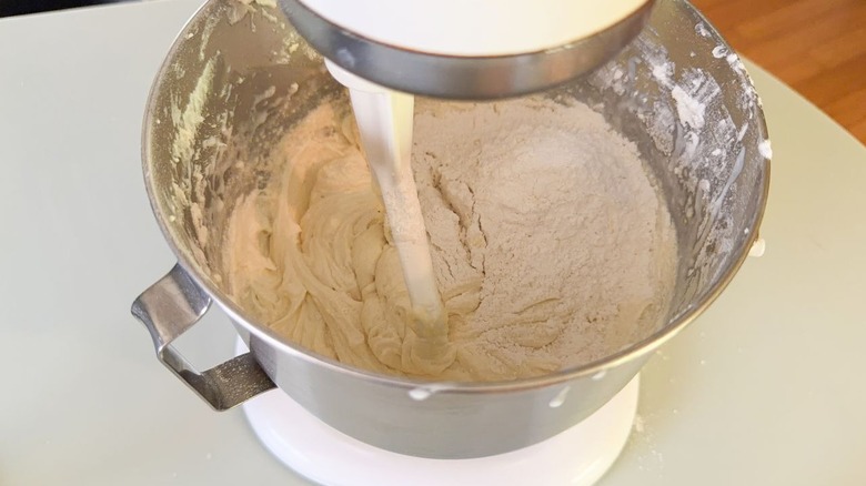 Dry ingredients added to cake batter in a stand mixer bowl