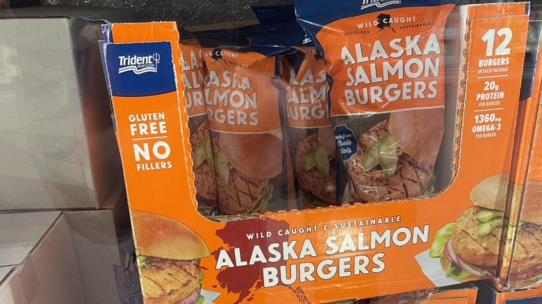 Cardboard case full of bags of Trident Seafoods Alaskan Salmon Burgers.