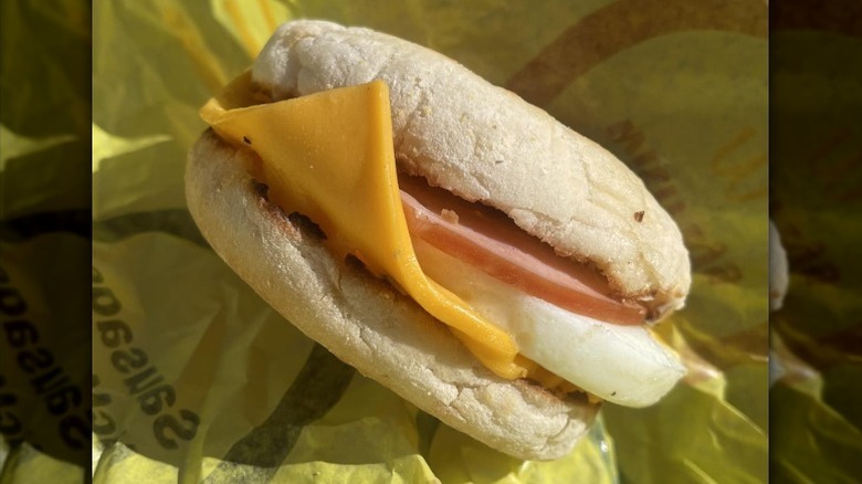 A McDonalds Egg McMuffin rests against a paper wrapper