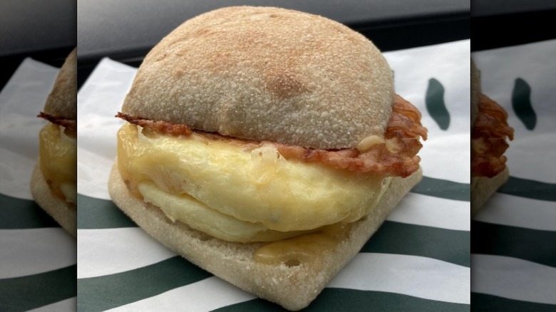 A Starbucks Bacon, Gouda, and Egg Sandwich sits on a paper wrapper