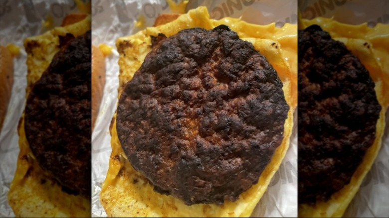 A burnt sausage patty on eggs and toast from a Sonic sausage breakfast toaster sandwich