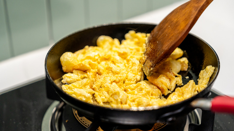 Scrambled eggs cooking in a pan.