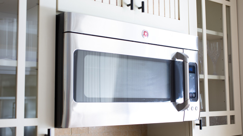 GE microwave suspended in a kitchen.