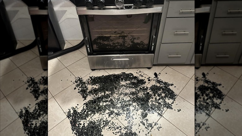 The glass from a shattered oven door sits on a kitchen floor