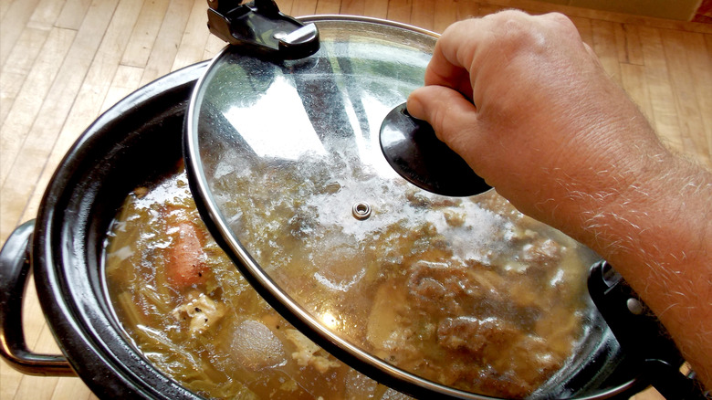 Someone opens a Crock-Pot lid.