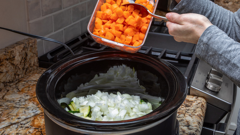 Chopped food scooped into a Crock-Pot.