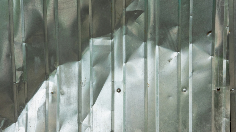 A dented aluminum fence