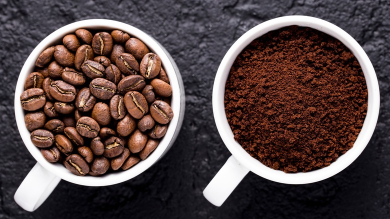 Roasted coffee beans and ground coffee in white mugs with handles
