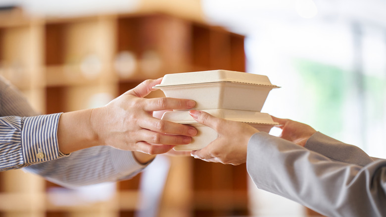A server hands someone to-go boxes