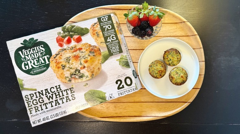 Veggies Made Great Spinach Egg White Frittatas on a plate next to their packaging and a bowl of berries