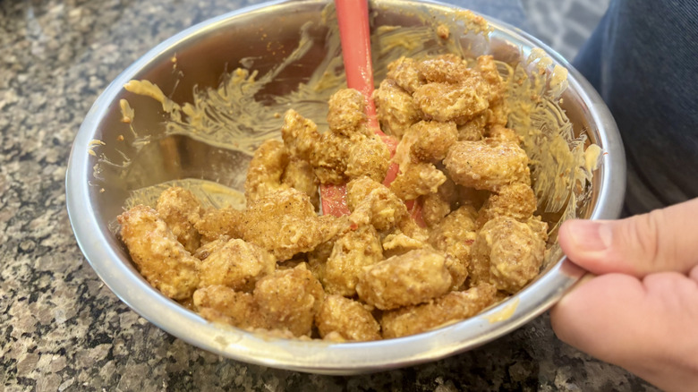 Stirring boom boom shrimp from costco in a metal bowl