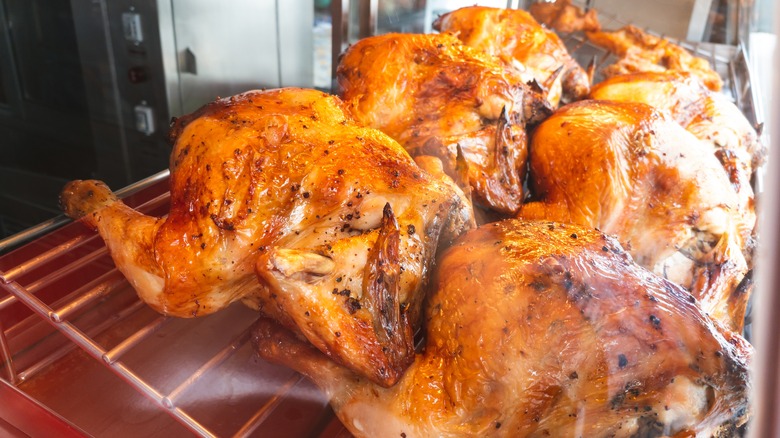 Seasoned rotisserie chickens sitting on a rack