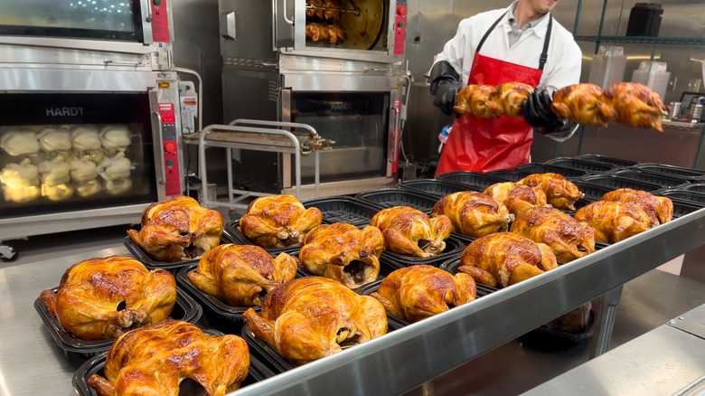 grocery store worker making rotisserie chicken