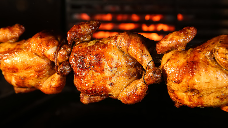 chickens cooking on a rotisserie
