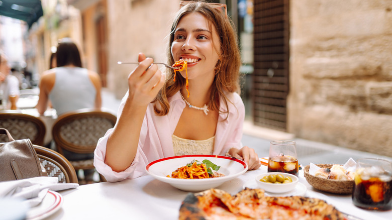 A diner enjoys a plate of pasta in Italy.