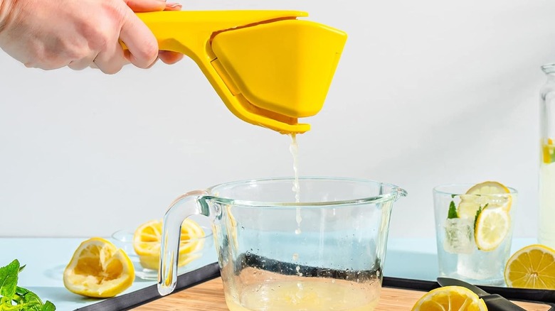 DreamFarm lemon juicer with lemons being squeezed into a pitcher