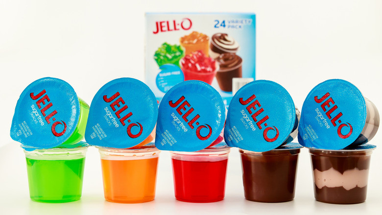 Various flavors of ready-to-eat Jell-O cups sit in front of a Jell-O variety pack box