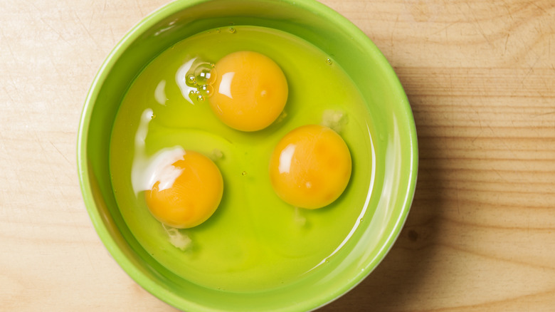 raw cracked eggs in bowl