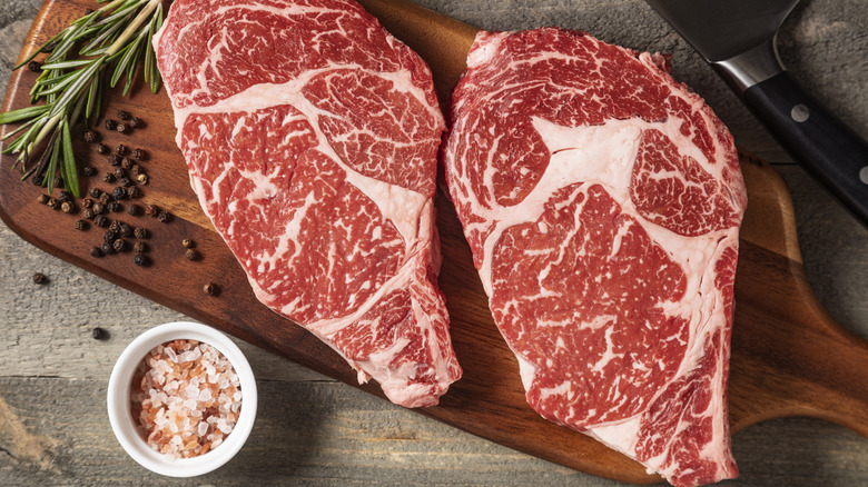 Two raw wagyu steaks sit on a cutting board