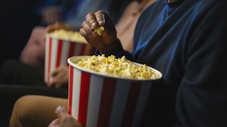 A hand holding popcorn.