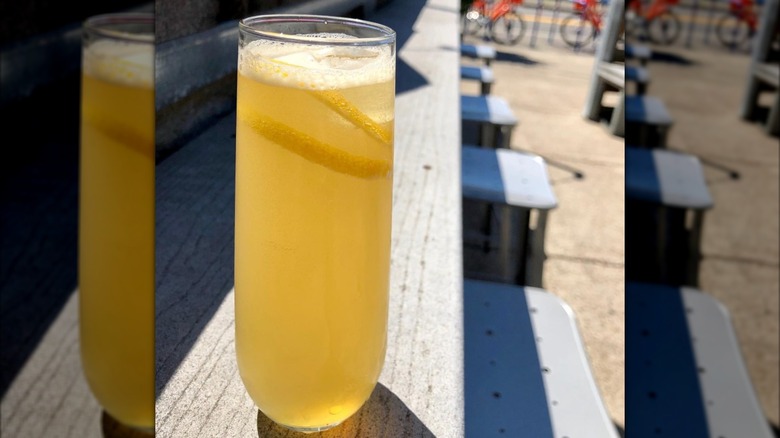 A French 95 cocktail with an orange peel garnish