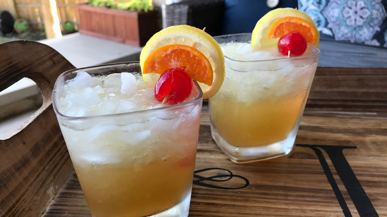 John Collins cocktails garnished with fruit.