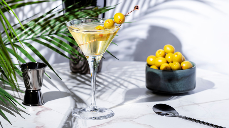 A dirty vodka martini garnished with olives.