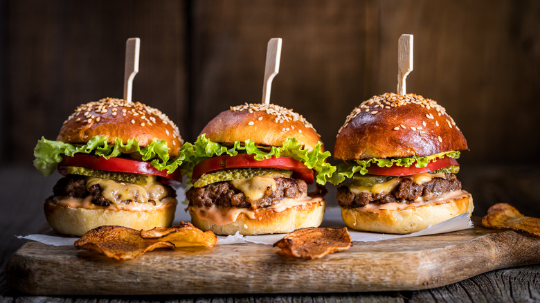 3 beef sliders on a wooden board