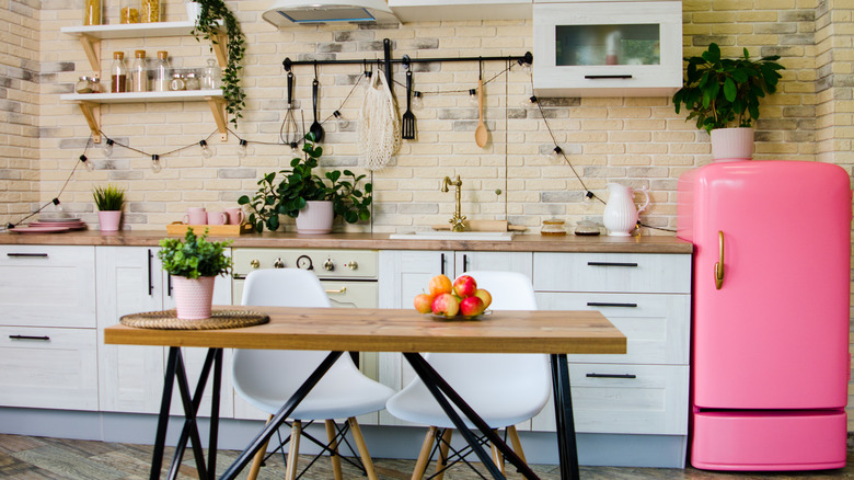 a pink statement refrigerator in a vintage kitchen