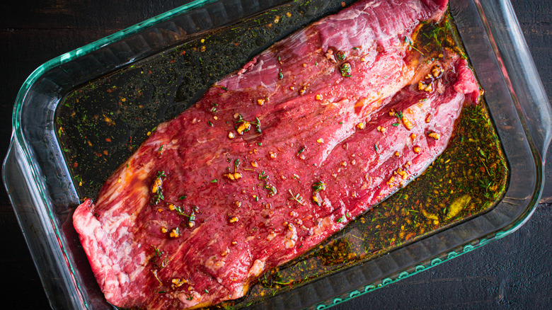 Steak marinating in glass dish