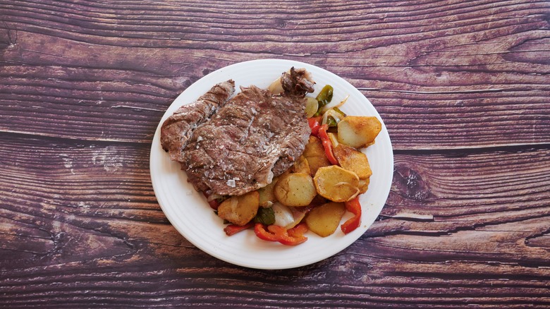 Cube steak and potatoes on wooden table