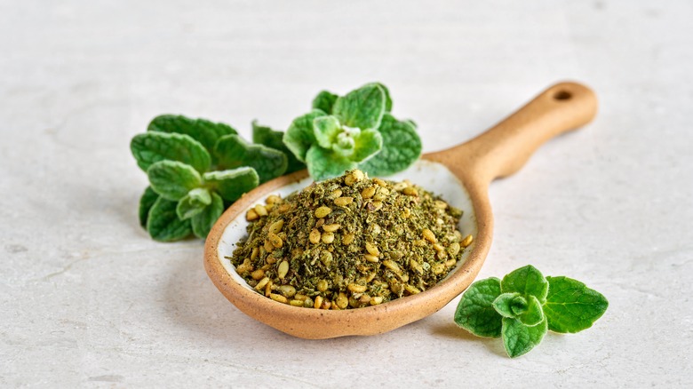 Za'atar in a bowl with fresh herbs.