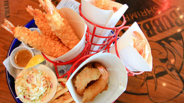 various fried seafood in cones with fries and coleslaw on a bubba gump shrimp table