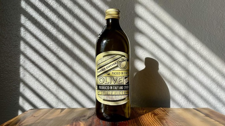 Bottle of Trader Giotto's Imported Olive Oil Packed In Italy on a wooden table