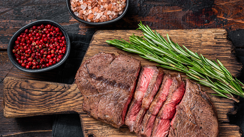 blade steak on wood board with rosemary and spices