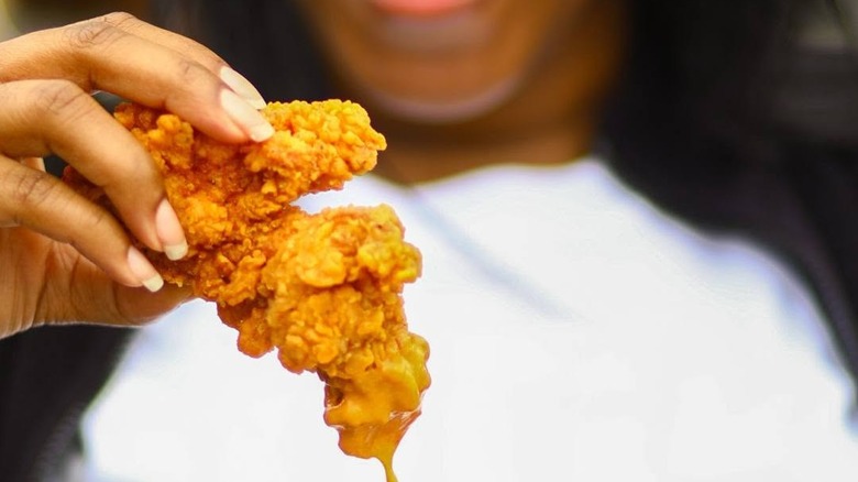 hand holding a chicken tender