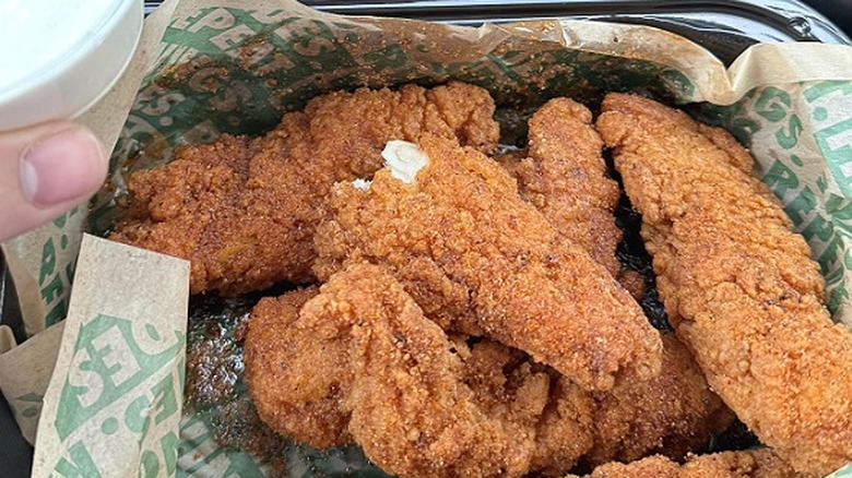 A large order of Wingstop chicken tenders in a to-go container